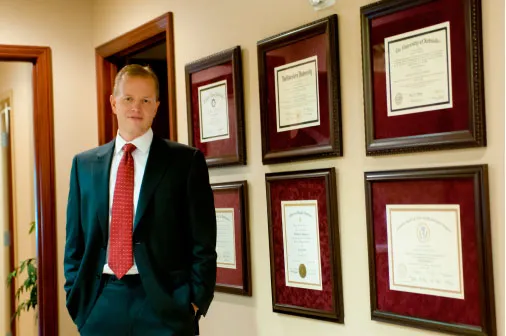Dr. Hammond standing around a set of his diplomas