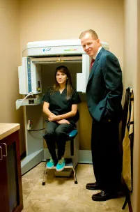 Dr. Hammond with a staff member sitting on a CAT scan machine