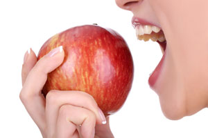 a woman about to bite an apple